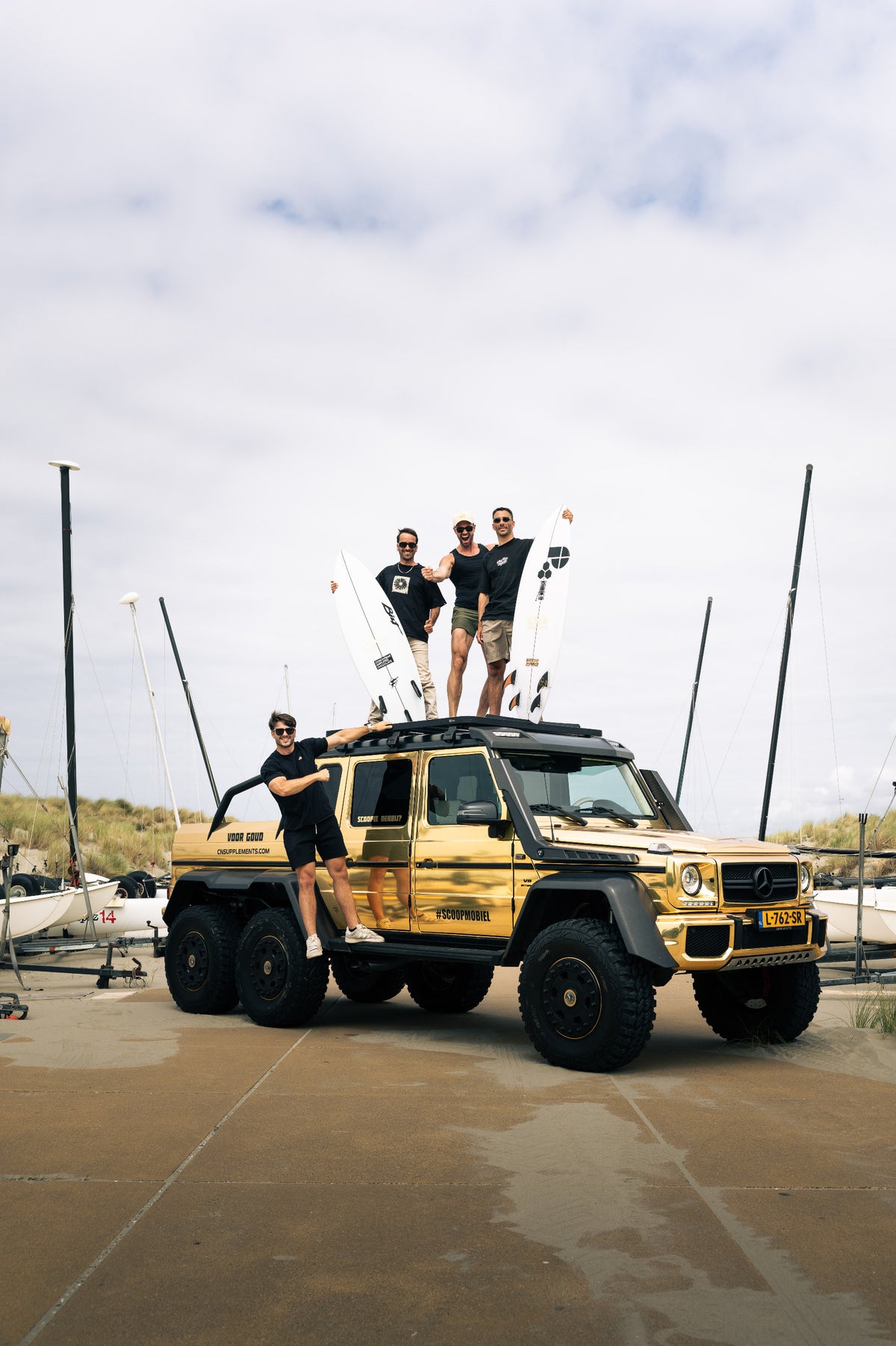 Groei-Maten mit Surfbrettern auf und neben dem goldenen Scoopmobiel